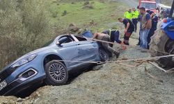 Otomobil yol kenarında asılı kaldı, araçtaki çift ölümden döndü