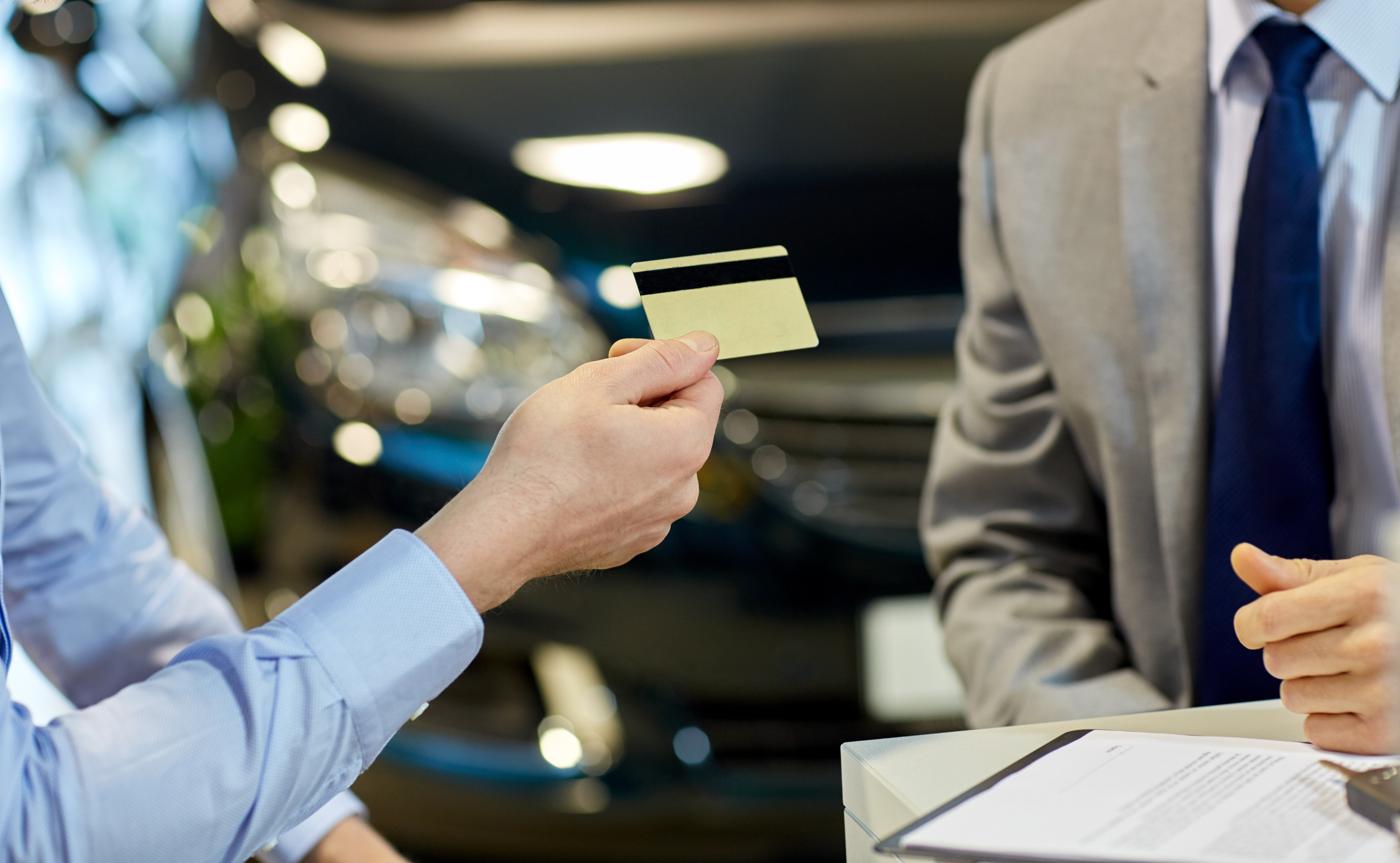 auto-business-sale-people-concept-close-up-customer-giving-credit-card-car-dealer-auto-show-salon