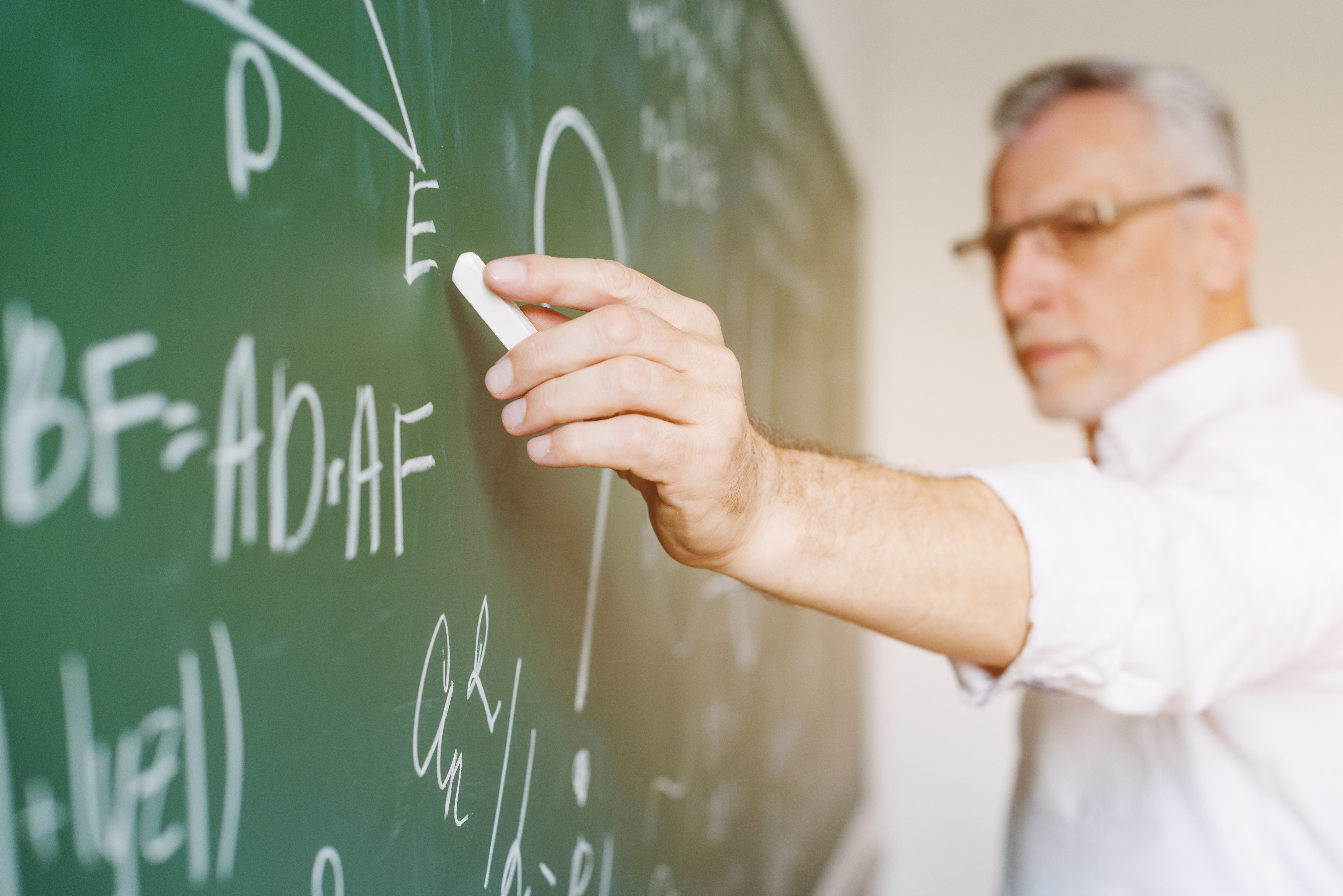aged-math-teacher-writing-chalkboard