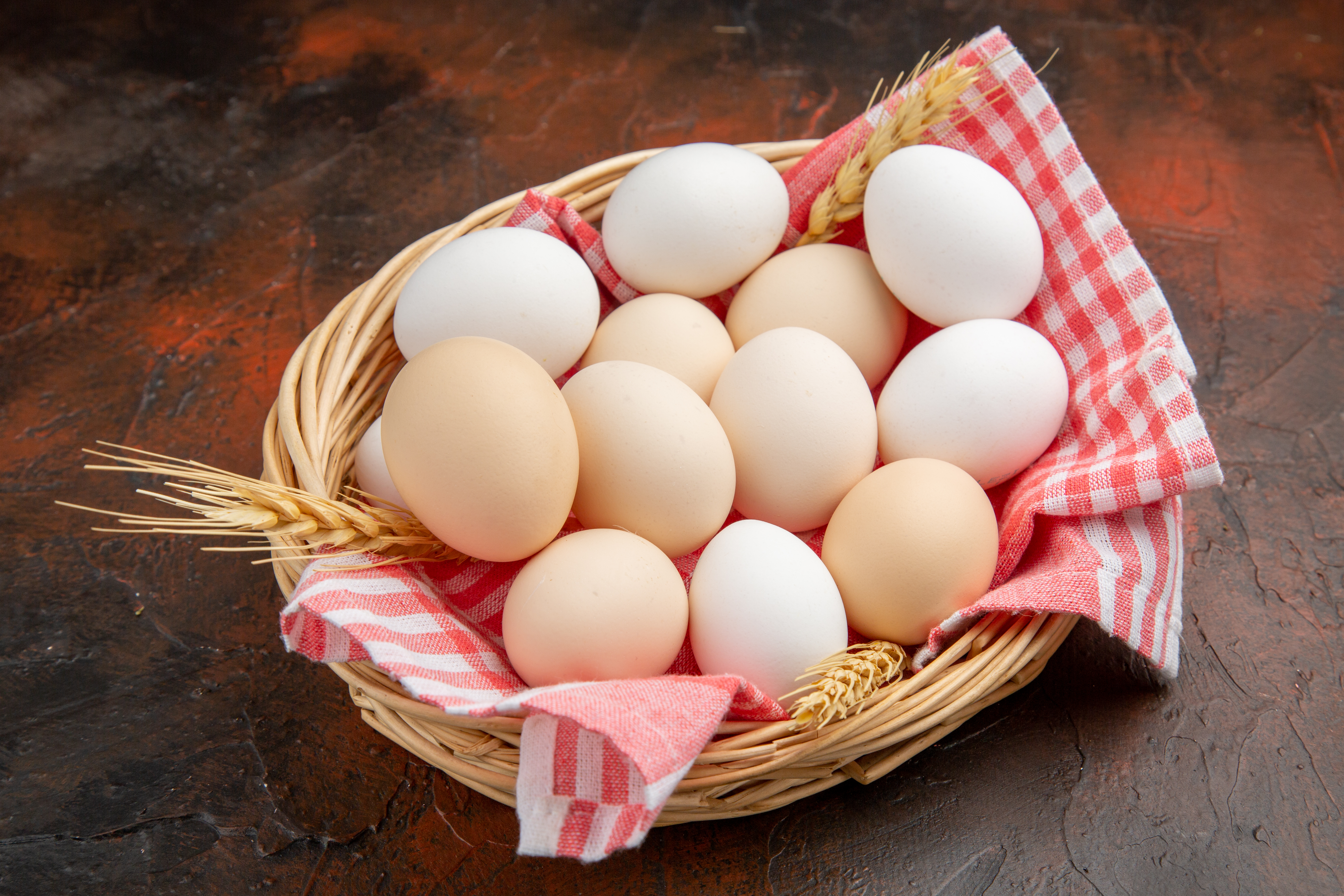 front-view-white-chicken-eggs-inside-basket-with-towel-dark-surface