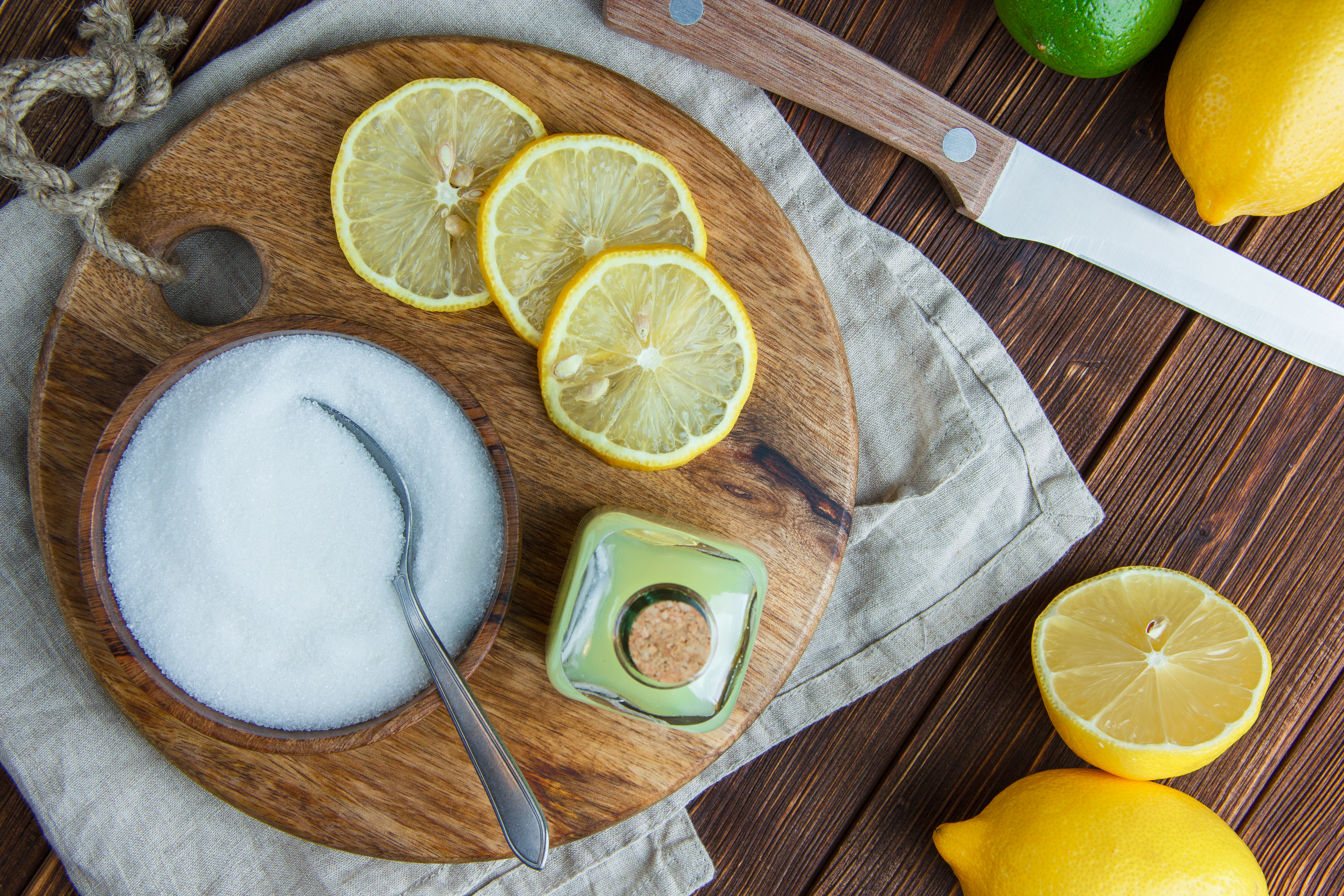 lemons-with-drink-cutting-board-salt-knife-flat-lay-wooden-kitchen-towel