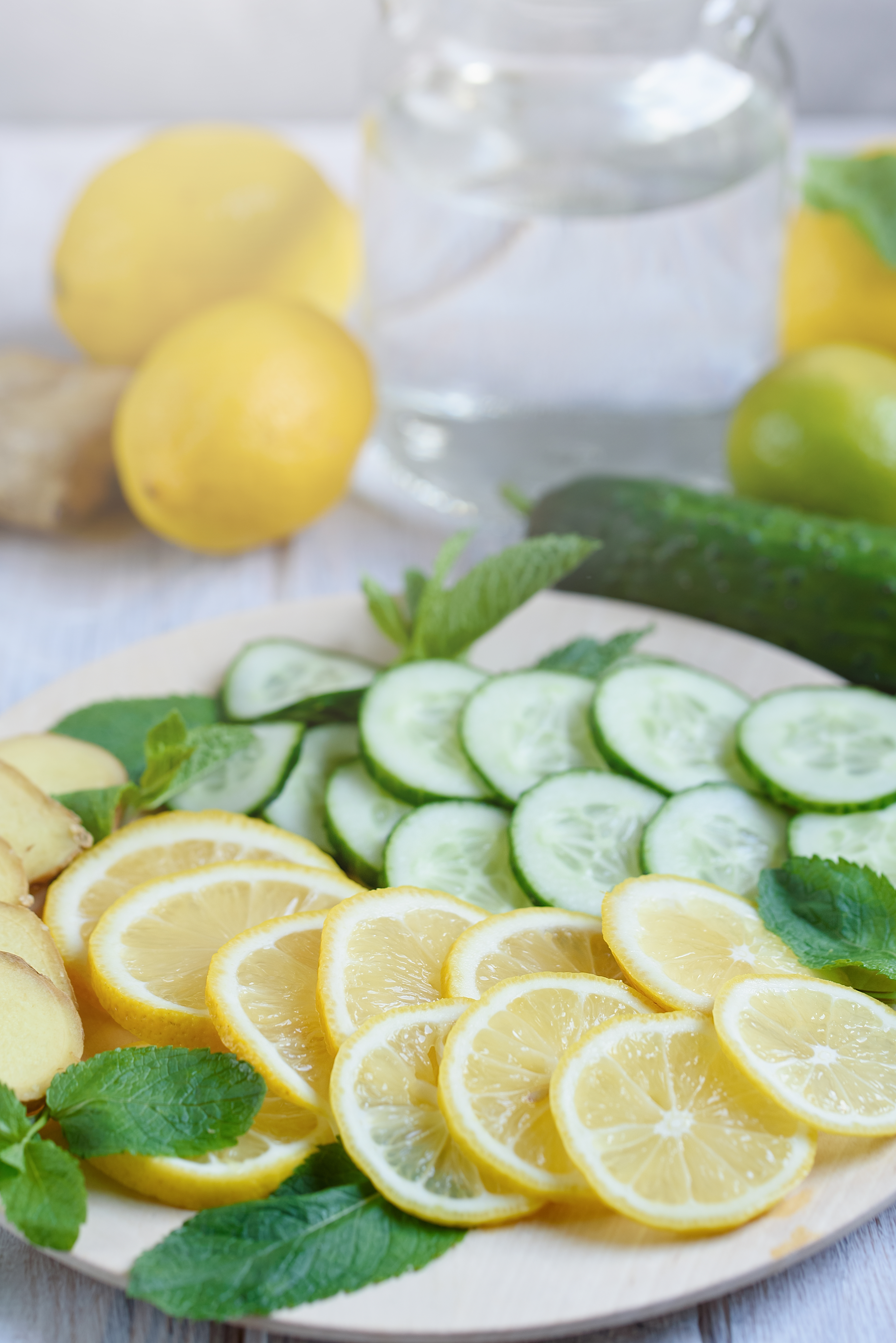 sassi-water-cooking-ingredients-making-sassi-drink-lemon-cucumbers-ginger-root-mint-round-wooden-tray