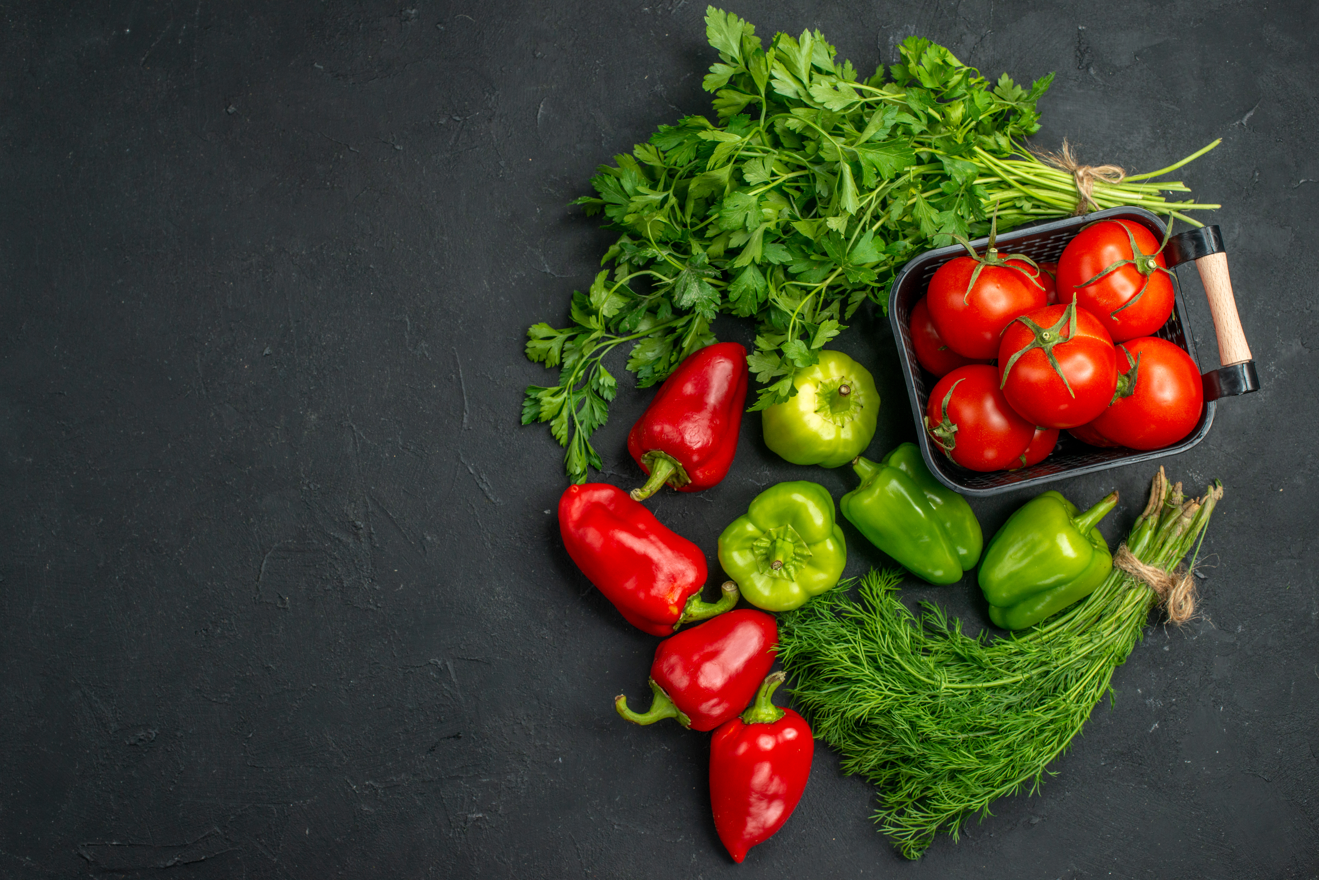 top-view-fresh-red-tomatoes-with-greens-bell-peppers-dark-background