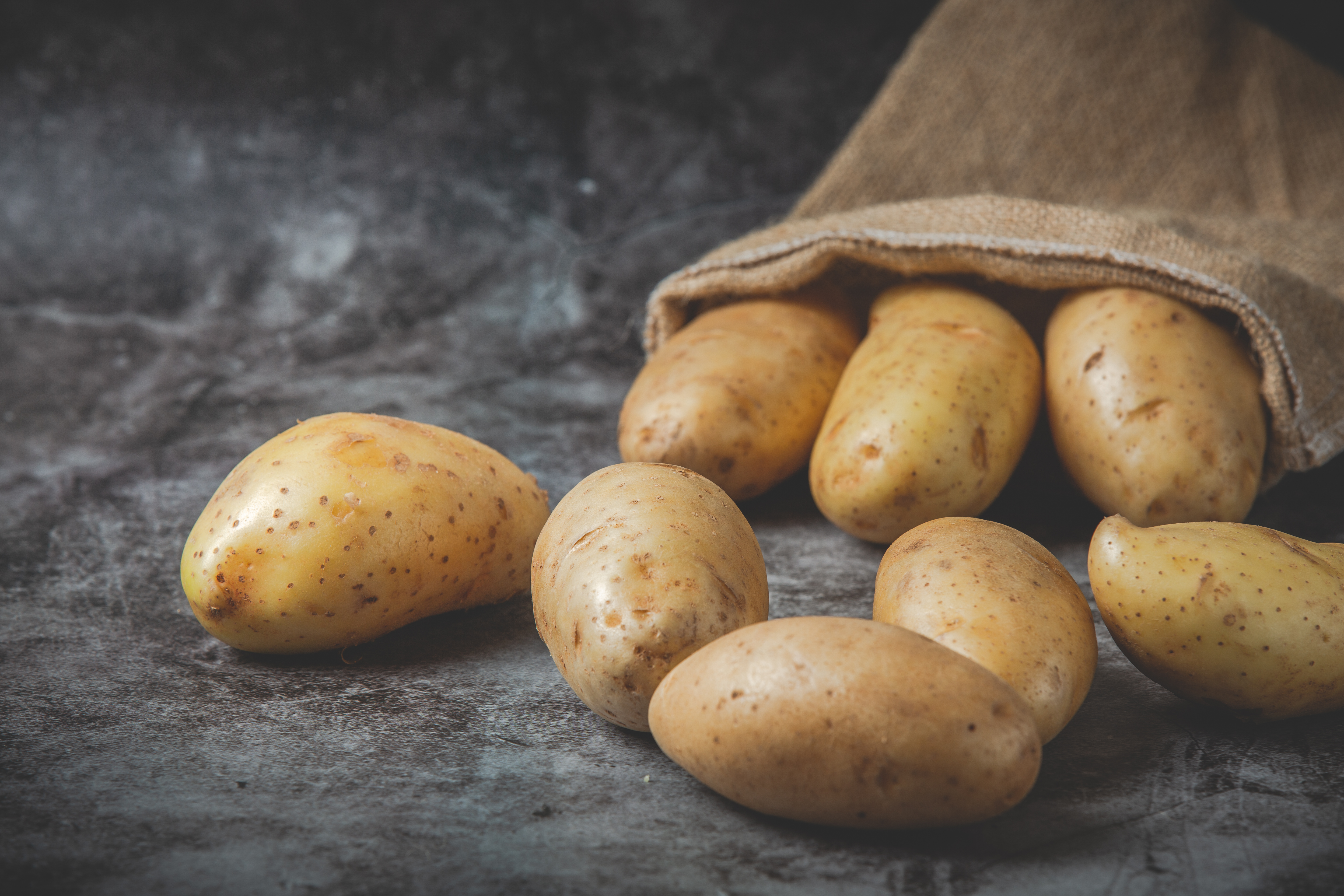 potatoes-pour-out-sacks-gray-floor