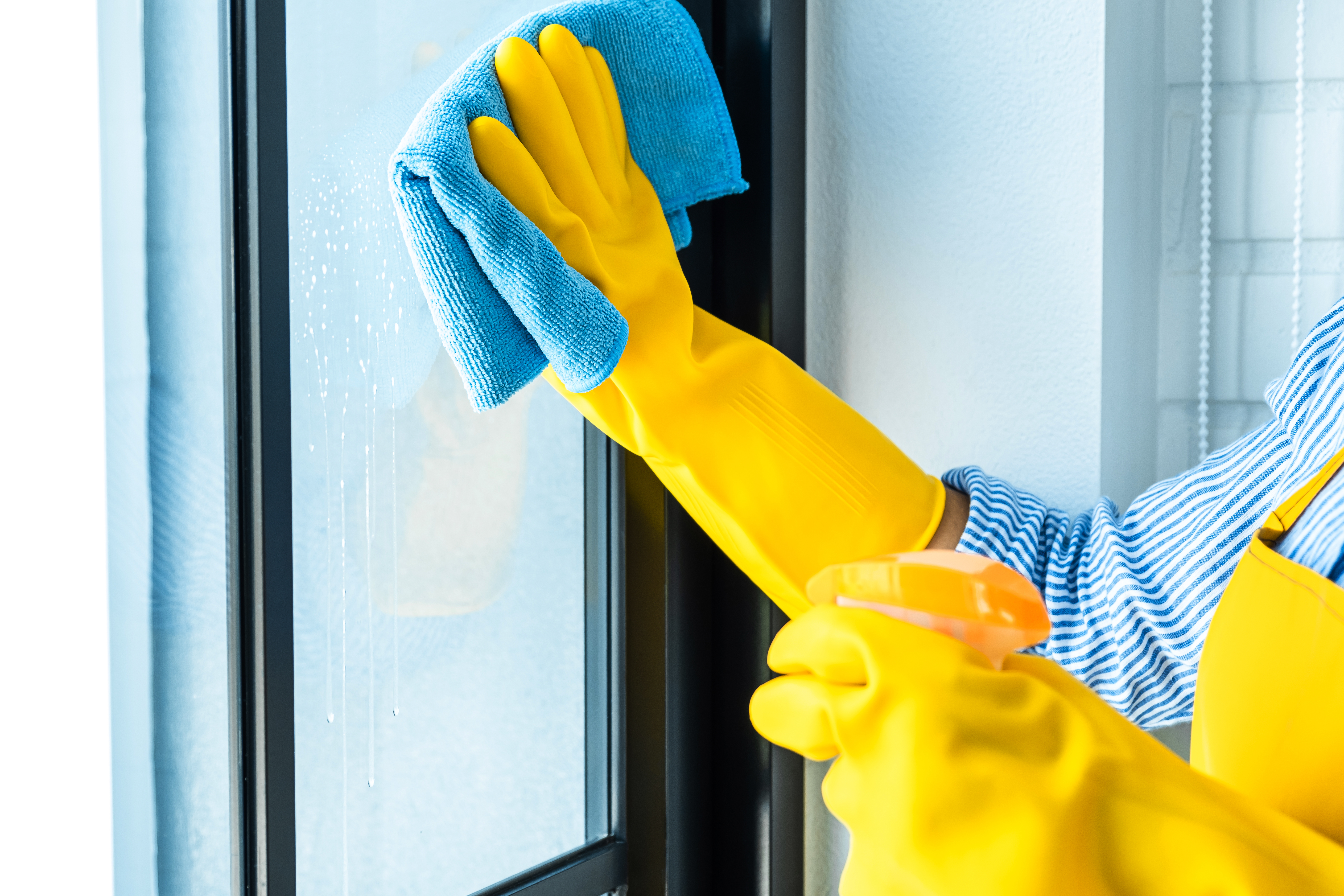 wife-housekeeping-cleaning-concept-happy-young-woman-wiping-dust-using-spray-duster-while-cleaning-glass-home