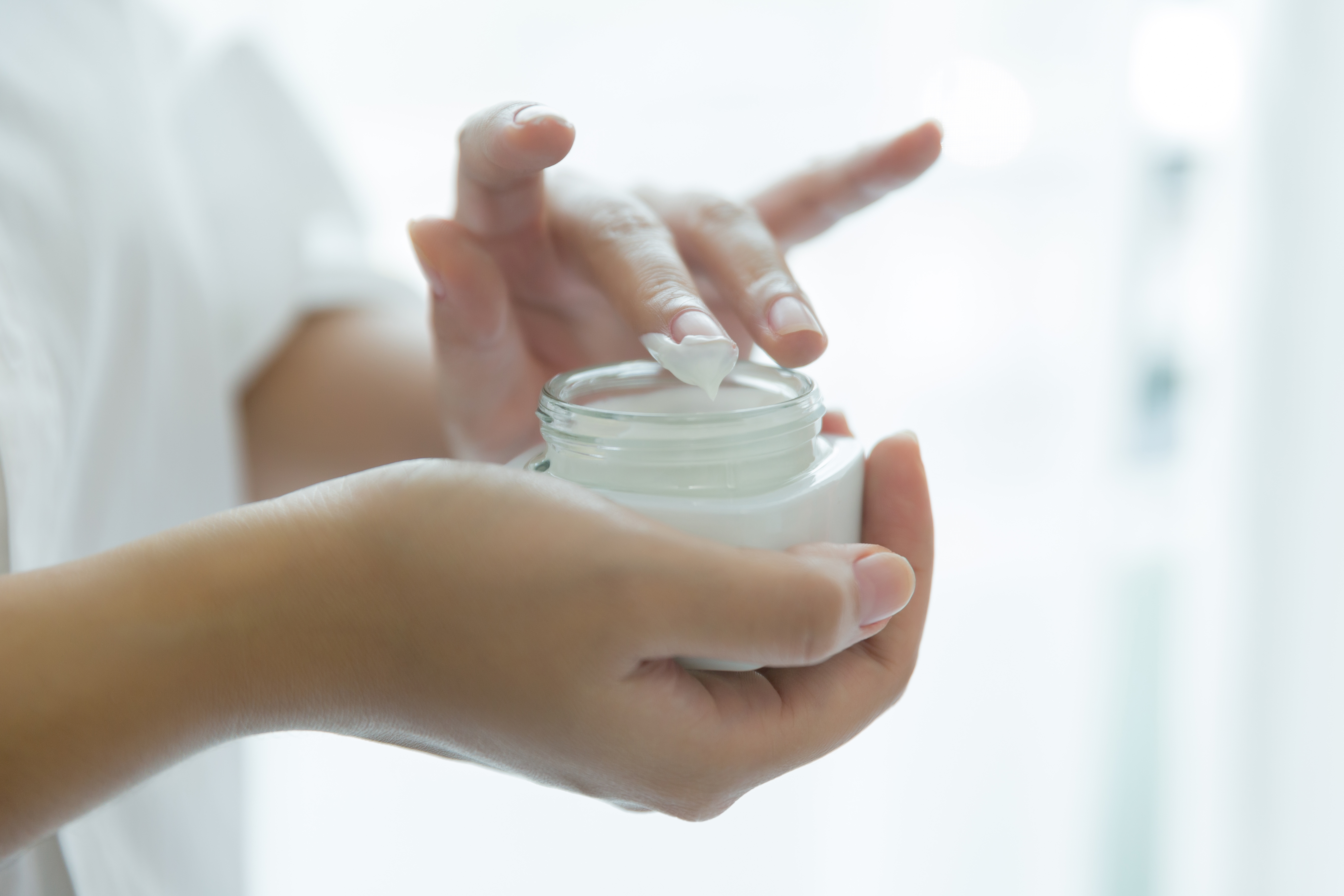 woman-holds-jar-with-cosmetic-cream-her-hands