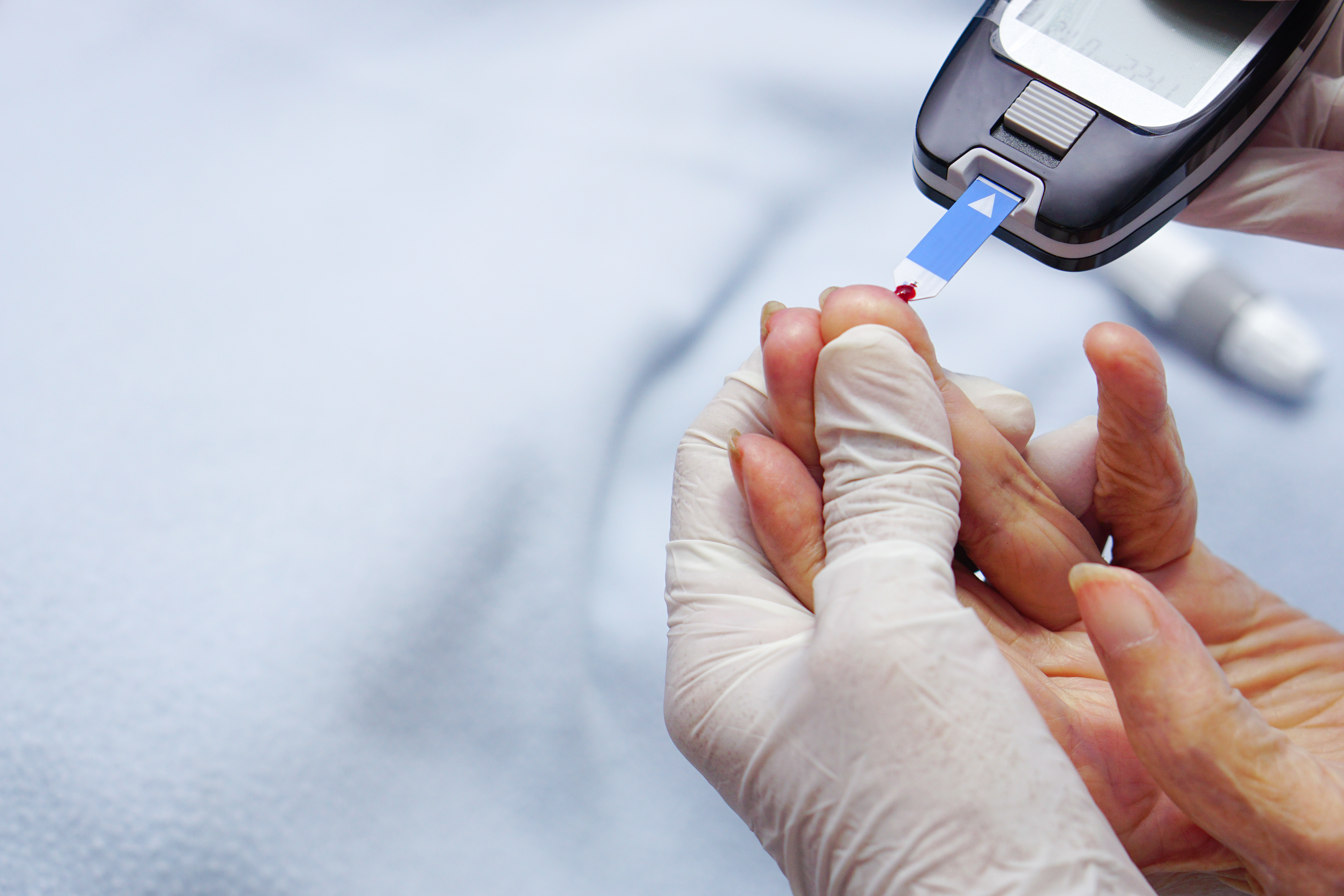 doctor-wear-gloves-using-lancet-finger-checking-blood-sugar-level-by-glucose-meter